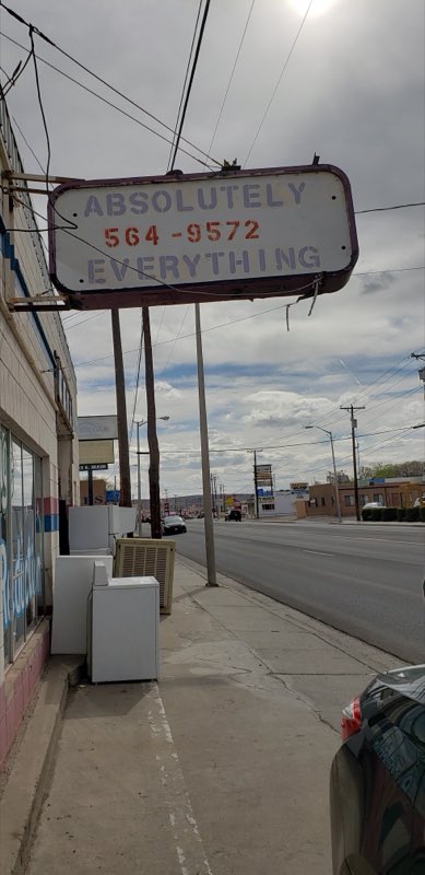 Roadside Absolutely Everything sign with used appliances lined up on the sidewalk